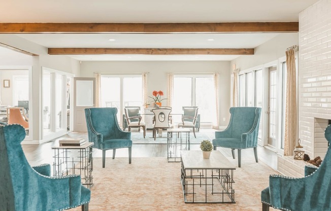 a living room with blue chairs and a fireplace