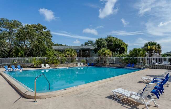 a swimming pool with chairs and chairs around it