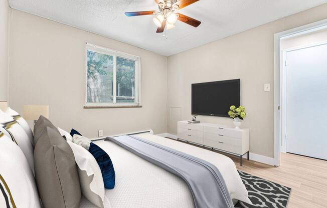 a bedroom with a large bed and a ceiling fan