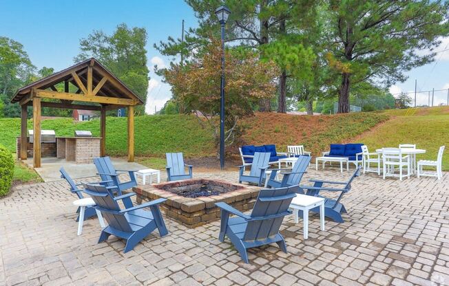 a patio with blue chairs and a fire pit