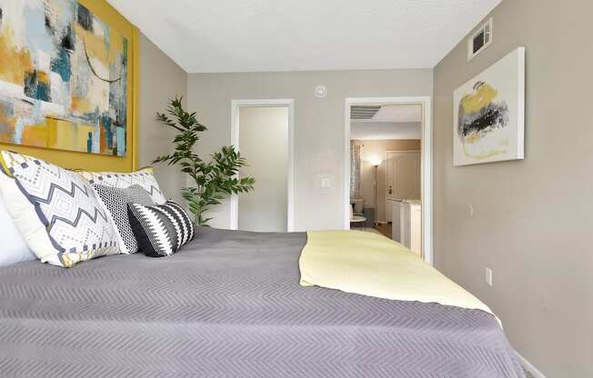 a bedroom with grey walls and yellow accents