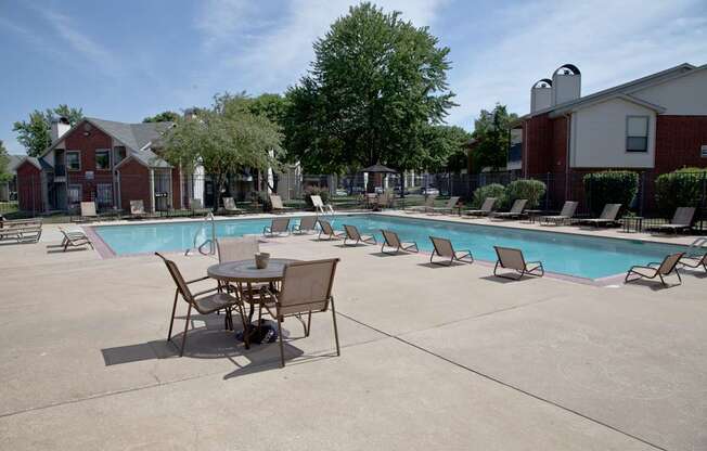 A table and chairs are set up by a pool.