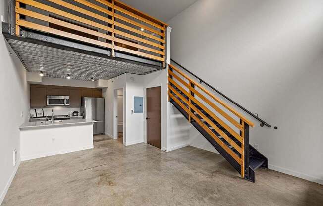A modern kitchen with a wooden staircase.