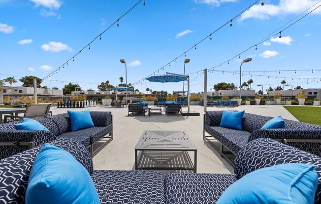 a seating area with blue couches and a table with blue pillows and a blue umbrella