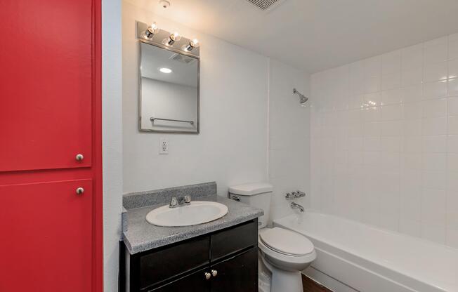 a white sink sitting under a mirror