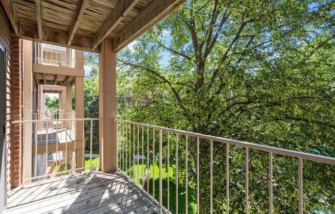 a balcony with a view of a yard and trees