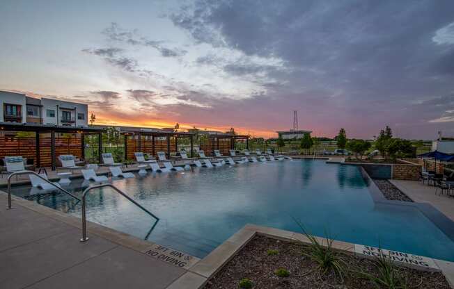 a swimming pool with lounge chairs at sunset at the grove resort and spa