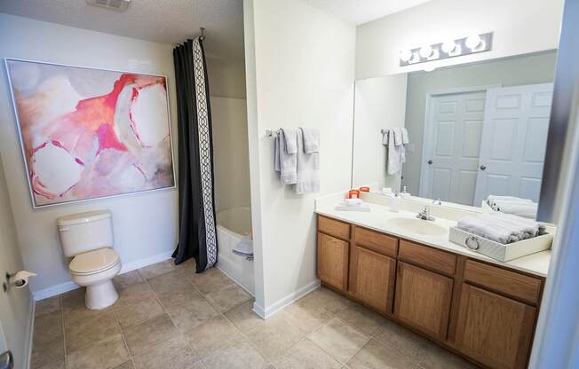 A bathroom with a toilet, sink, and shower.