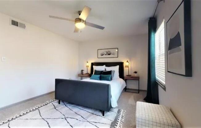 A bedroom with a large bed and a ceiling fan.