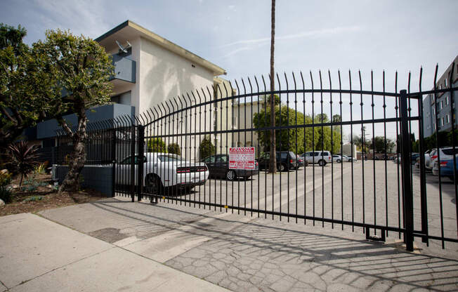 a gate with cars parked in front of a building