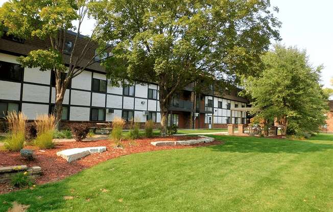 the courtyard of an apartment building with grass and trees