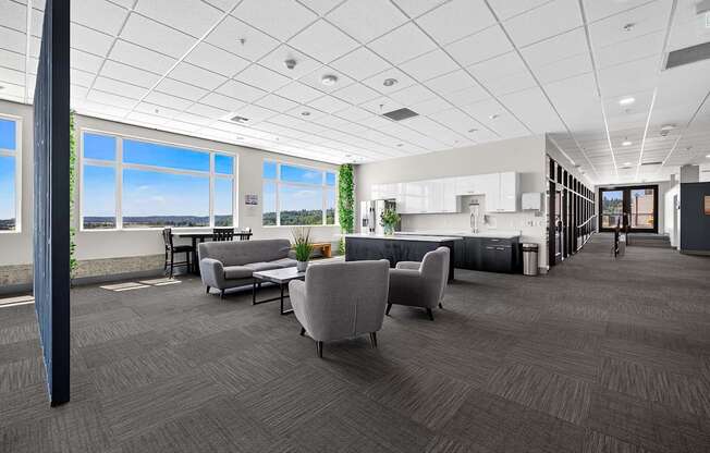 A spacious office with grey carpeting and furniture.