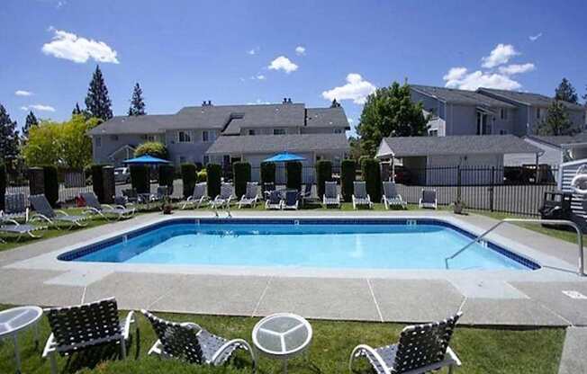 a swimming pool with chairs and chairs around it