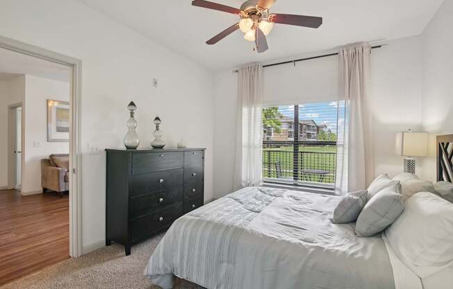 A bedroom with a large bed and a ceiling fan.
