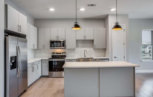 a kitchen with white cabinets and stainless steel appliances
