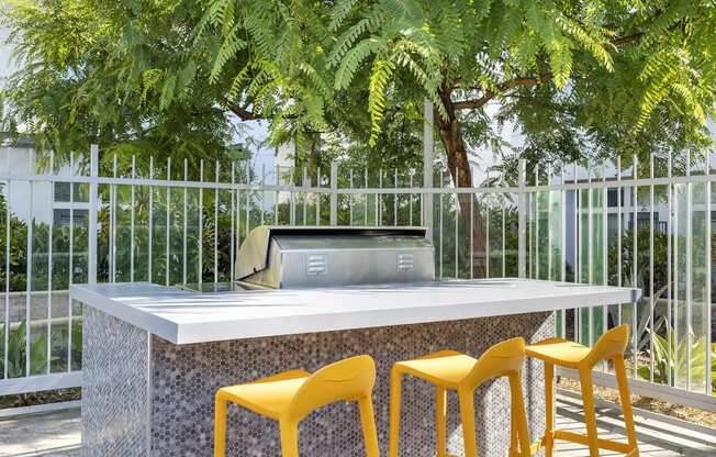 a table with yellow chairs in front of a glass building