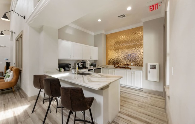 a kitchen with white cabinets and a marble counter top