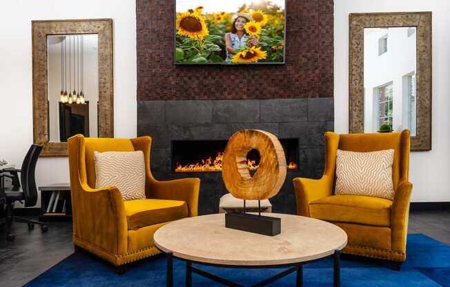 a living room with yellow chairs and a fireplace     and a table