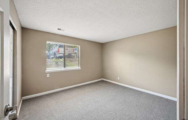 the living room of an empty apartment home with a window