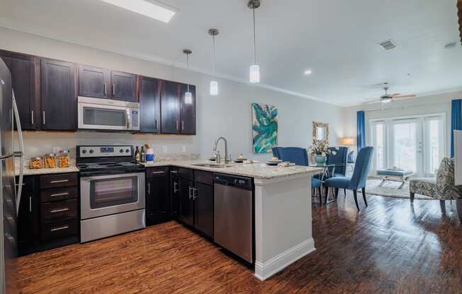 an open kitchen and living room with a large island and stainless steel appliances