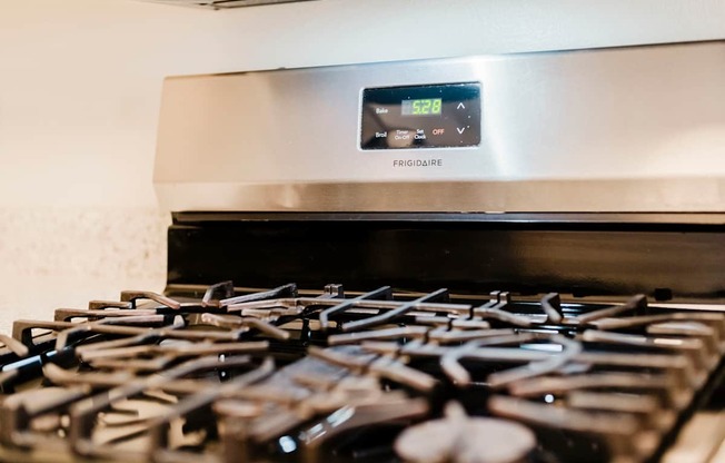 A Frigidaire stove top with a digital clock showing 5:24.
