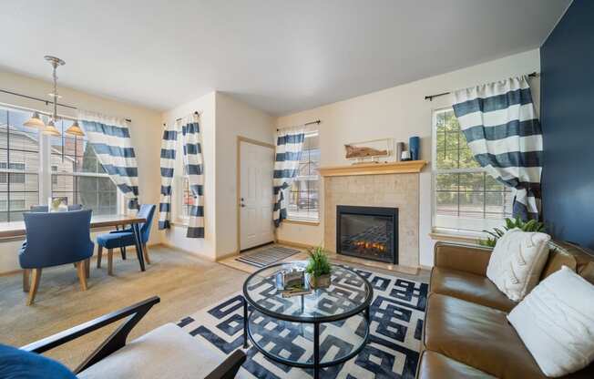 an open living room with a fireplace and a table with a couch and a chair