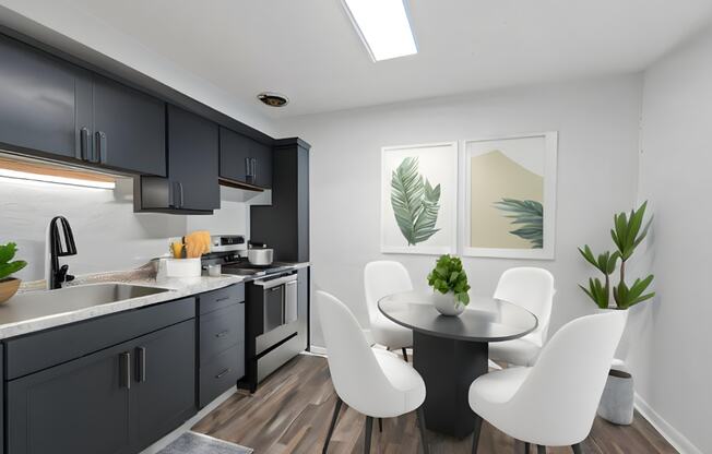 a kitchen with black cabinets and a table and chairs