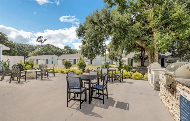 an outdoor patio with tables and chairs and trees
