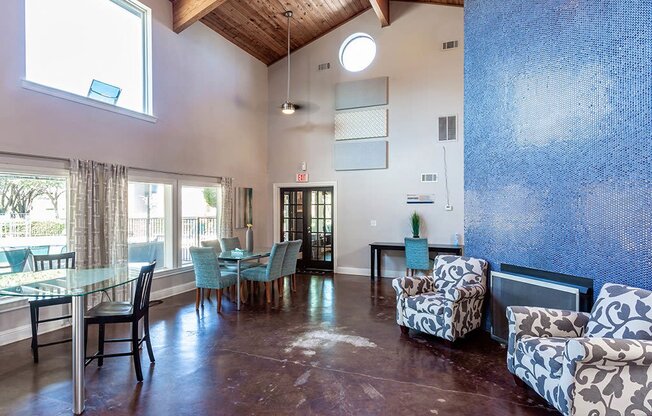 a living room and dining room with a glass table and chairs