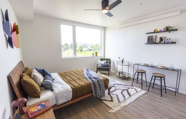 a bedroom with a bed and a desk and a window at Analog PDX Apartments, Portland, OR