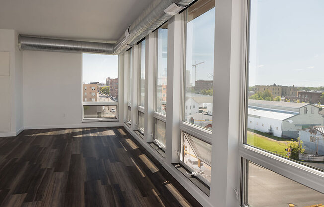 a living room with large windows and a wooden floor at The Landing at 1001 NP, Fargo, North Dakota 58102