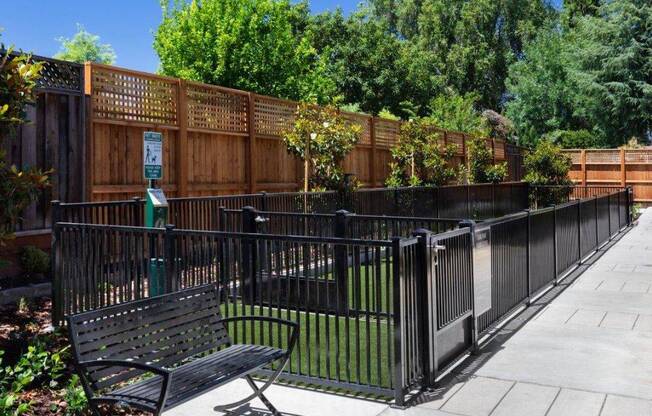 a park bench sitting in front of a fence
