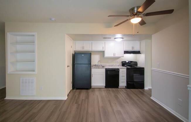 This is a photo of the kitchen and living room with built-in bookshelf of the 560 square foot 1 bedroom, 1 bath Elm floor plan at Montana Valley Apartments in Cincinnati, OH.