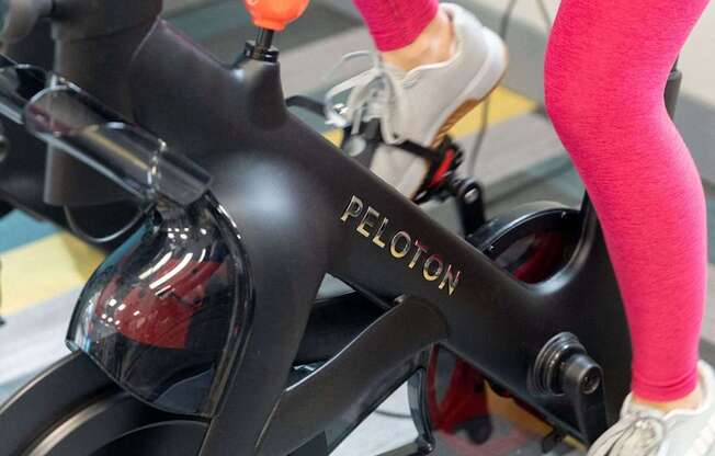 A person is riding an exercise bike with the brand name "E-TRACTION" visible on the handlebars.