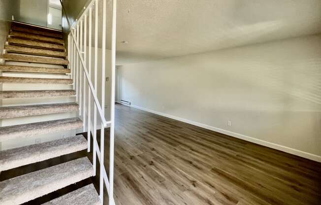 the upstairs of a house with stairs and wood flooring