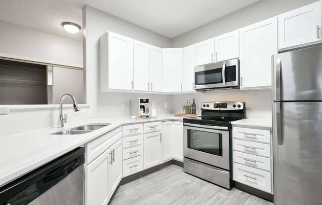 Modern and spacious kitchen with white cabinetry, stainless steel appliances, and plenty of storage.