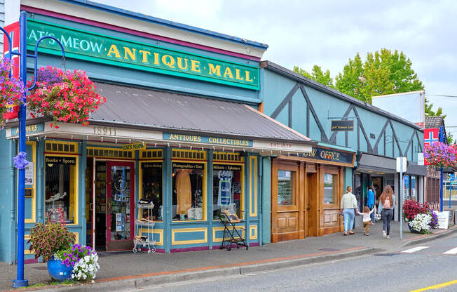 people walking down a street in front of an antique mall at Woodcreek, Poulsbo, WA 98370