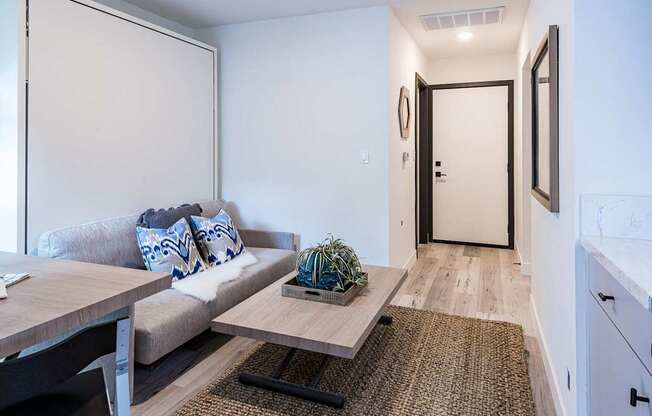 A modern living room with a grey couch and a wooden coffee table.