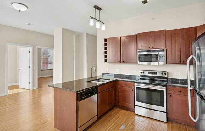 an empty kitchen with wooden cabinets and stainless steel appliances