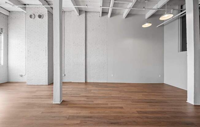 A large, empty room with wooden floors and white walls.