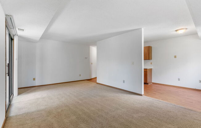 an empty living room with white walls and wood flooring