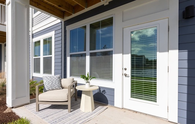 a front porch with a chair and a table and a door