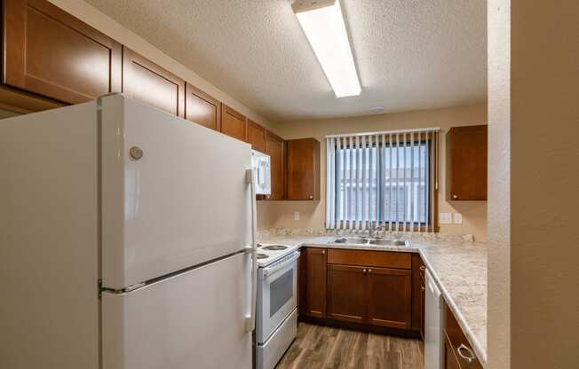 Grand Forks, ND Richfield Apartments. A kitchen with white appliances and a window.