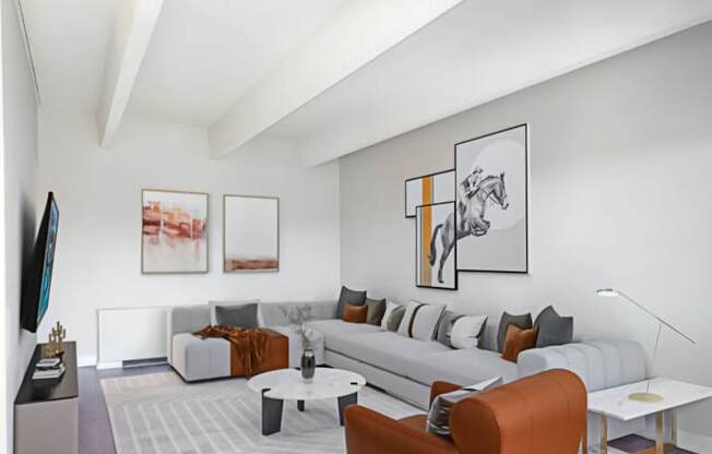 A living room with a grey couch, a coffee table, and a painting on the wall.