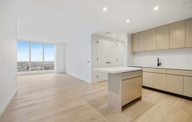 a living room with a kitchen and a window at The Paxton, Brooklyn, New York