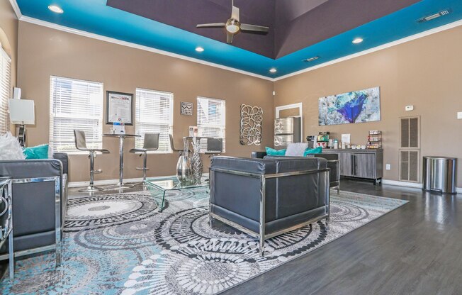 A modern clubhouse with a ceiling fan and a patterned rug at The Drake in Bossier City, LA