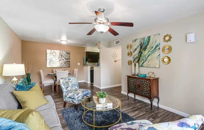 a living room with a ceiling fan and a couch and chairs
