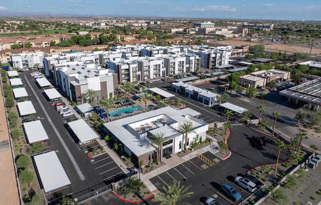 A bird's eye view of a parking lot with cars and buildings.