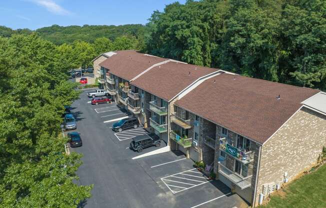 a view of a building with a parking lot and trees