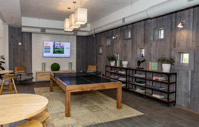 a game room with a ping pong table and a flat screen tv
